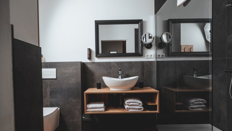 Modern bathroom with washbasin, mirror, toilet and shower.