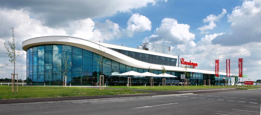 Modern building with glass façade and curved roof.