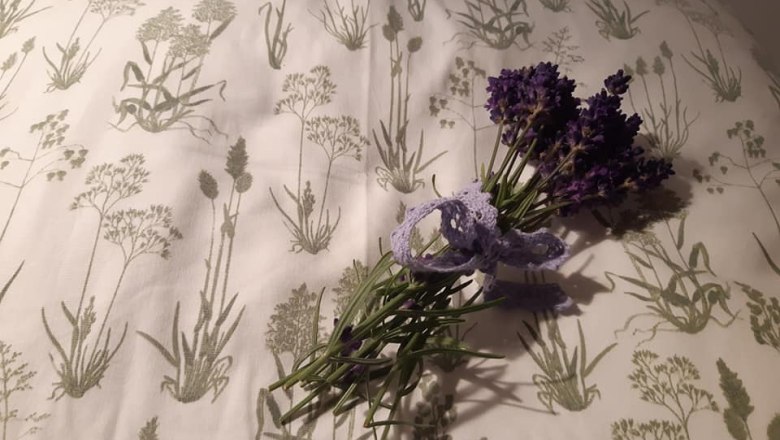 A bouquet of lavender lies on a cushion with a plant pattern.