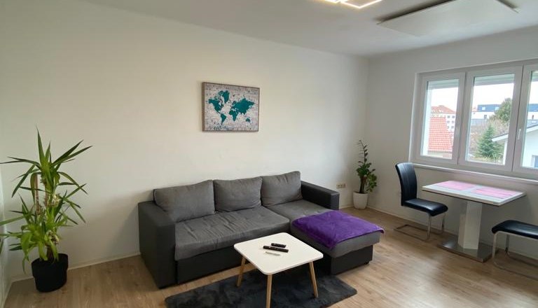 Living room with couch and pictures on the wall and large window