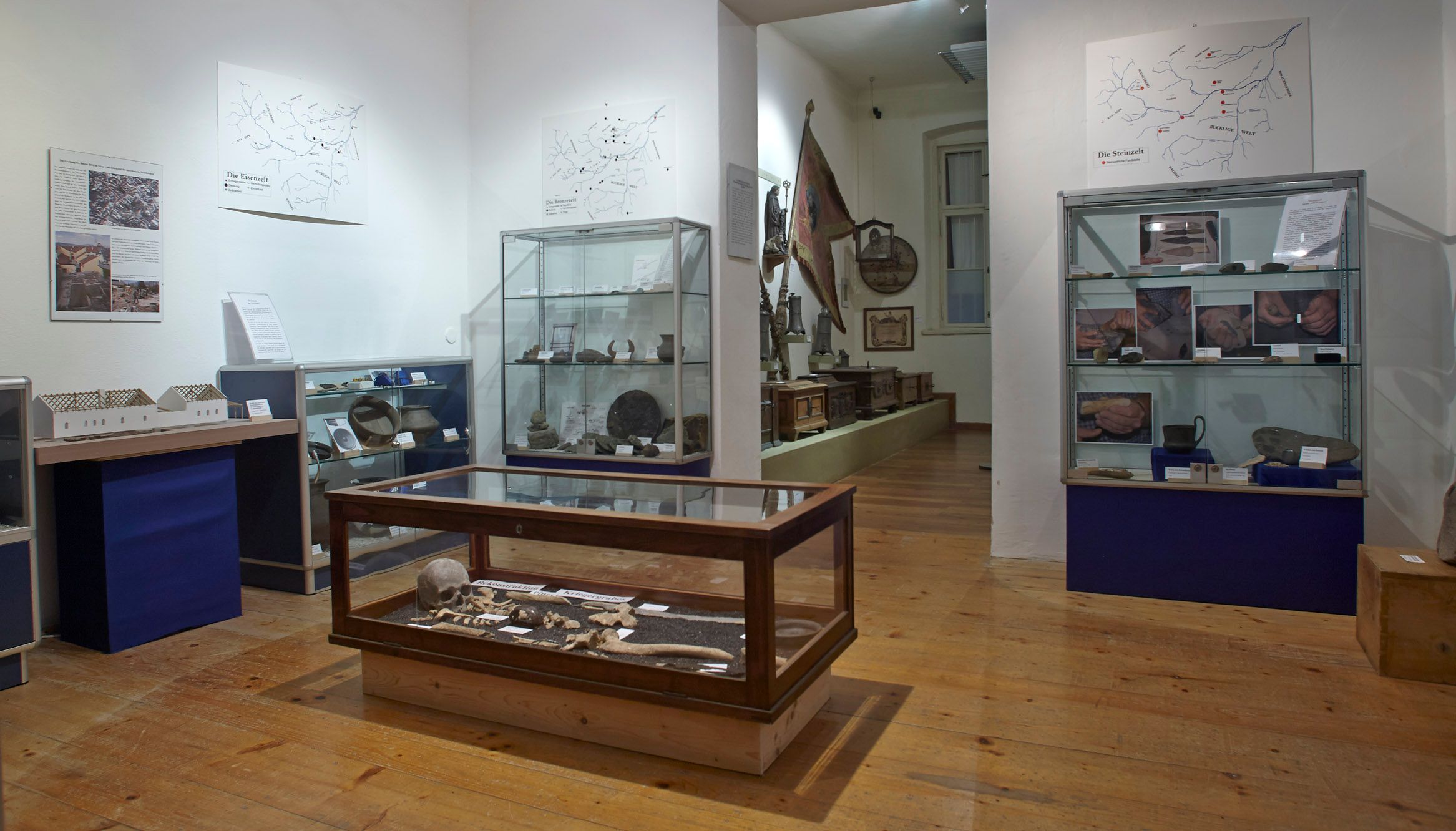 Interior view of a museum with display cases full of archaeological artifacts.