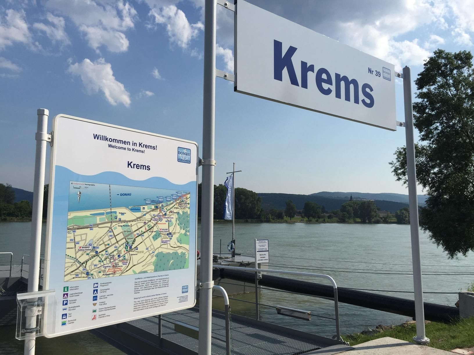 Jetty in Krems with welcome sign and map, river in the background.