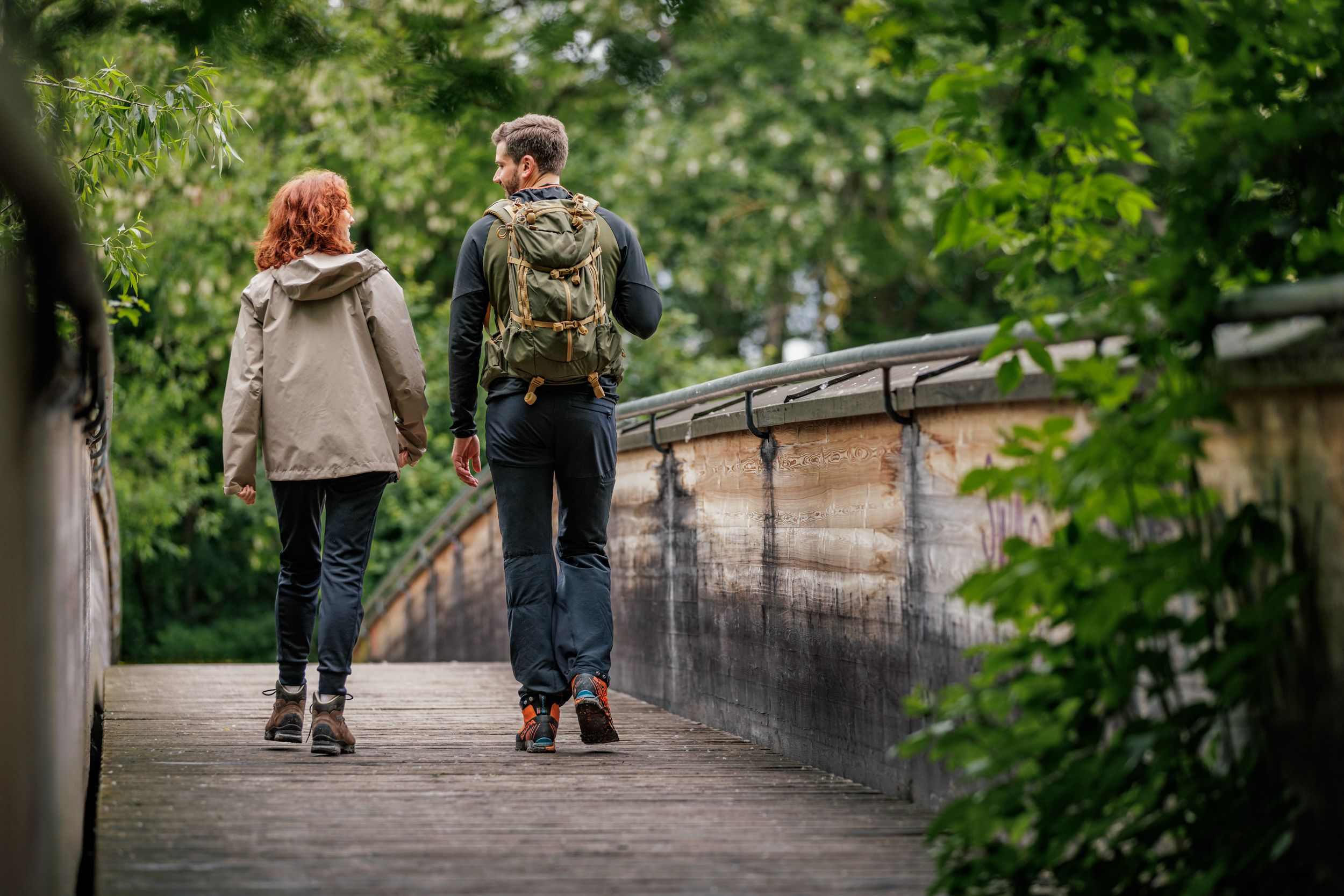 Two hikers on a wooden bridge in the forest