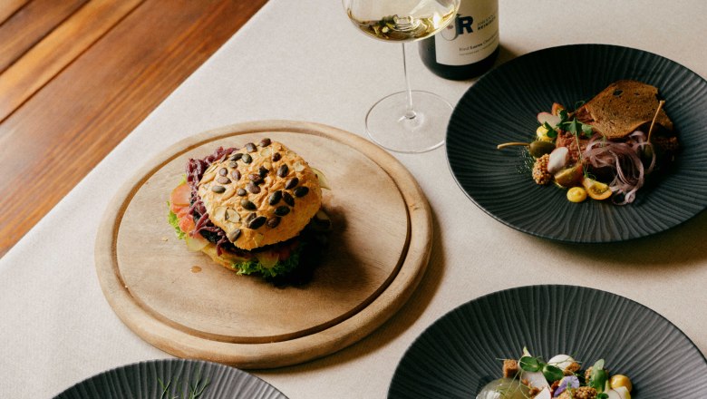 Gourmet dishes on a table with wine.