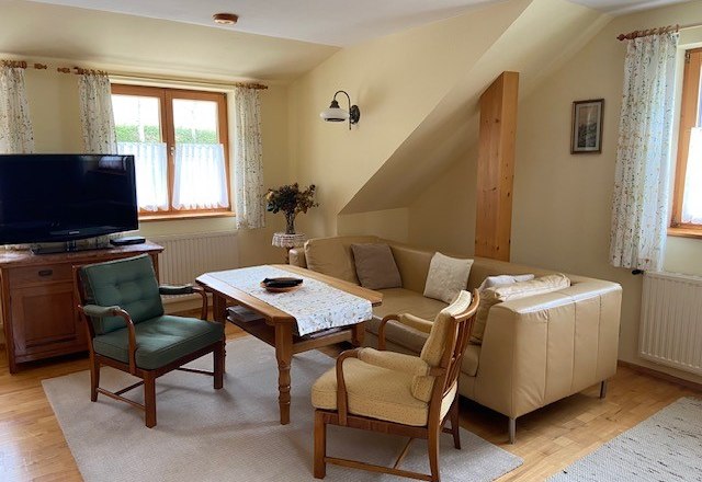 Cozy living room with sofa, armchairs and TV.