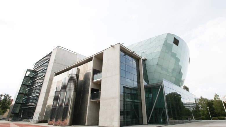 Modern building with glass façade and geometric shapes.