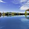 A modern pool on a penthouse with a view of the mountains and blue sky.