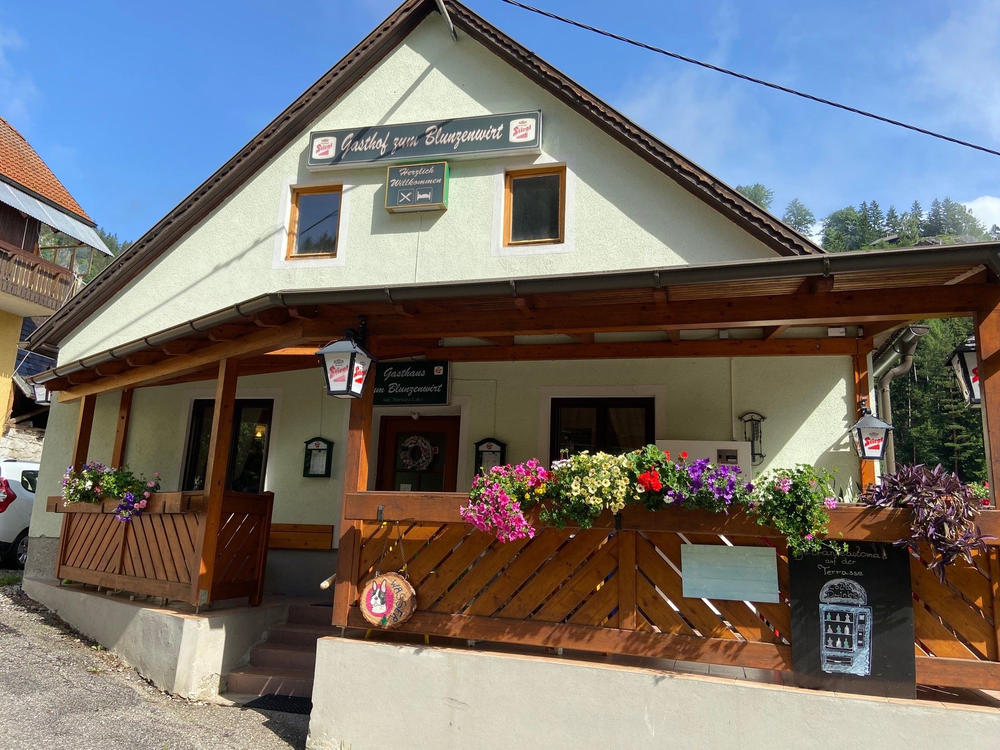A traditional inn with a wooden veranda and flower boxes, labeled 'Gasthof zum Blunzenwirt'.