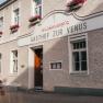 Gasthof zur Venus with flower-decorated façade and wooden door.