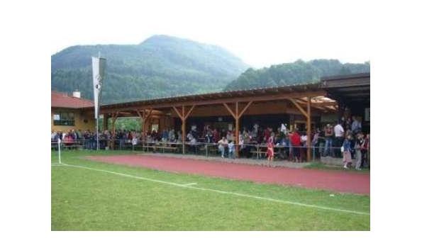 Crowd on a sports field with mountains in the background.