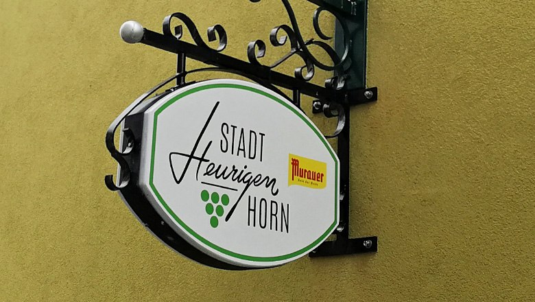 Sign of the Stadtheurigen Horn on a yellow wall.