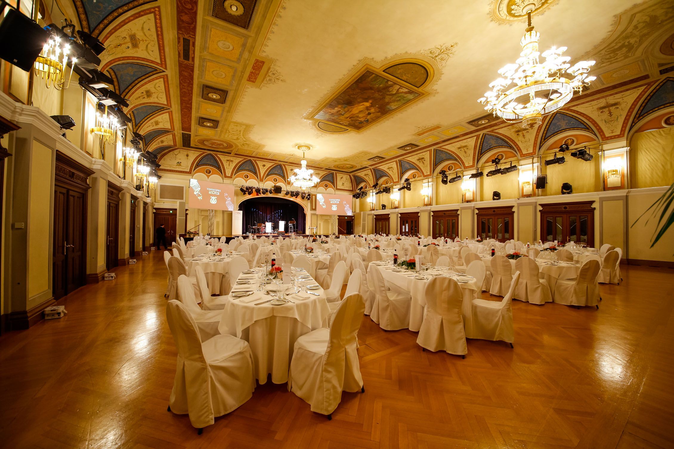 Elegant ballroom with laid tables and chandeliers in the Congress Center Baden.