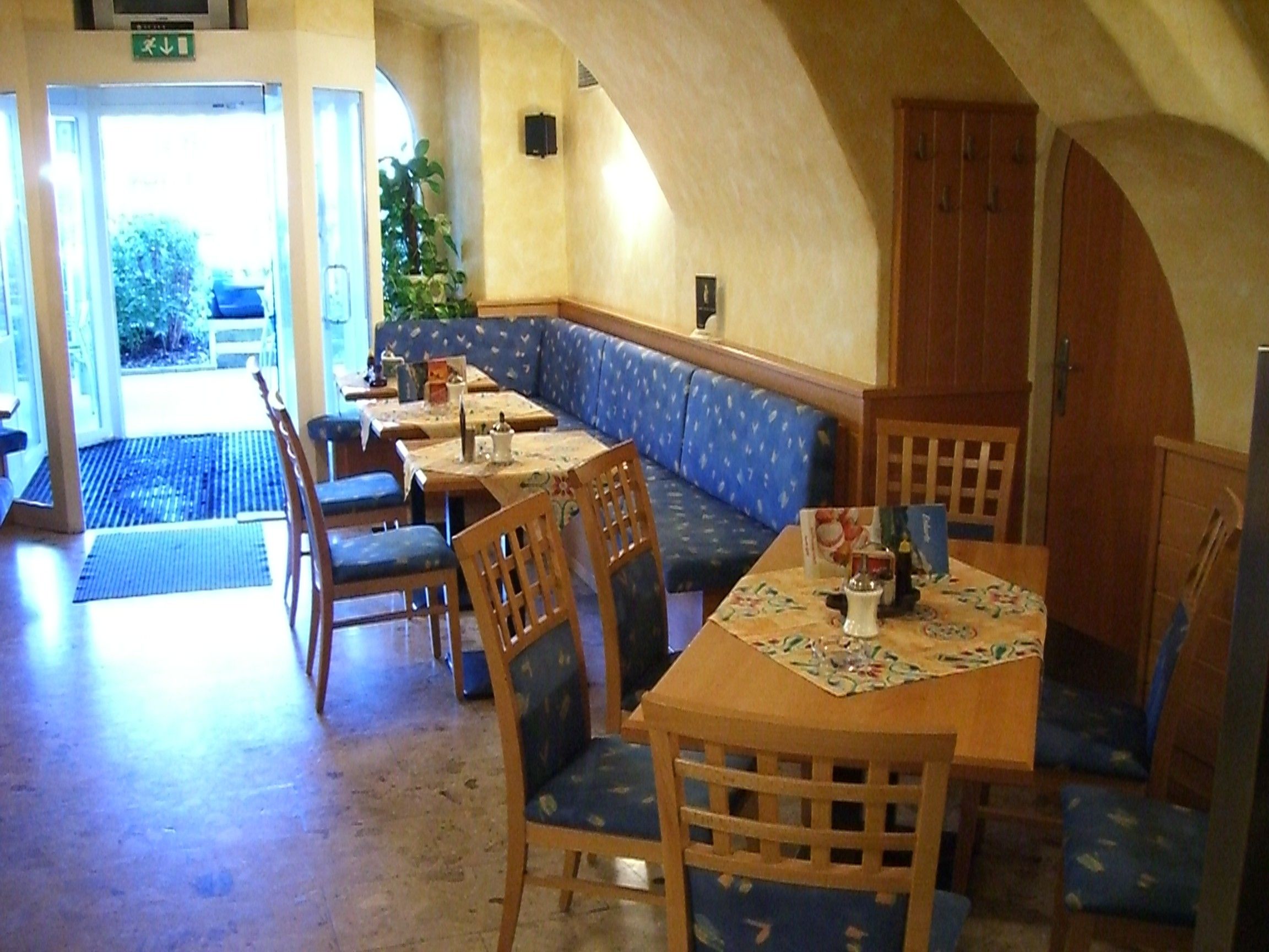 Interior view of a cozy café with wooden furniture and blue upholstery.