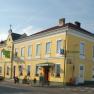 Yellow pub on a street corner with several windows and an entrance.