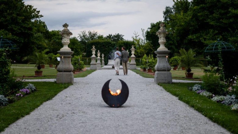 Historic courtyard garden Seitenstetten Abbey, © Unrath A gravel path in the historic courtyard garden of Seitenstetten Abbey with sculptures and plants, a fireplace in the foreground.