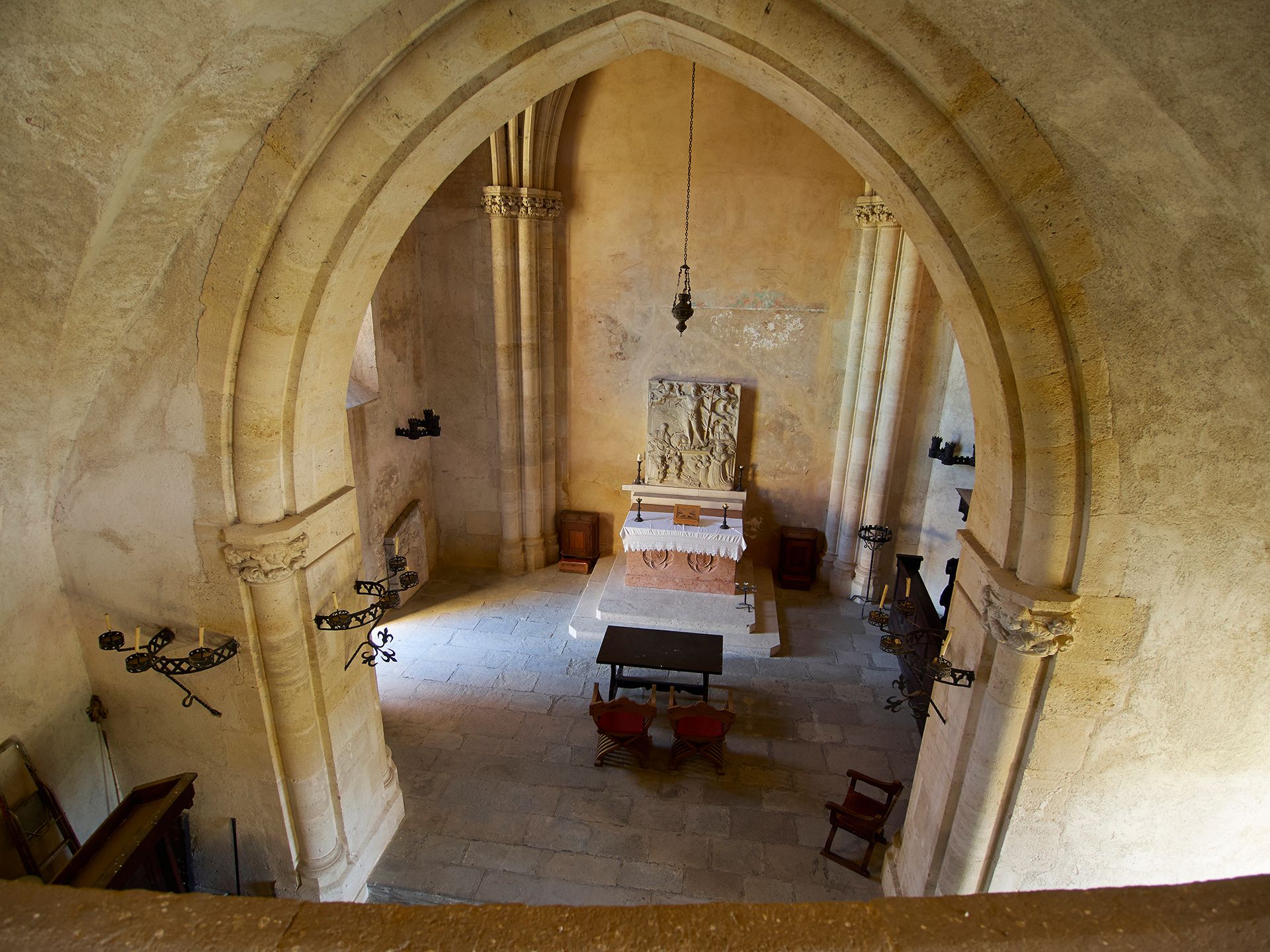 Interior view of a historic chapel with altar and Gothic arches.