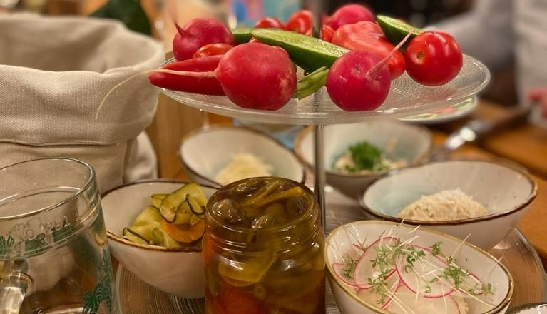 A table with various bowls full of vegetables and pickled dishes.