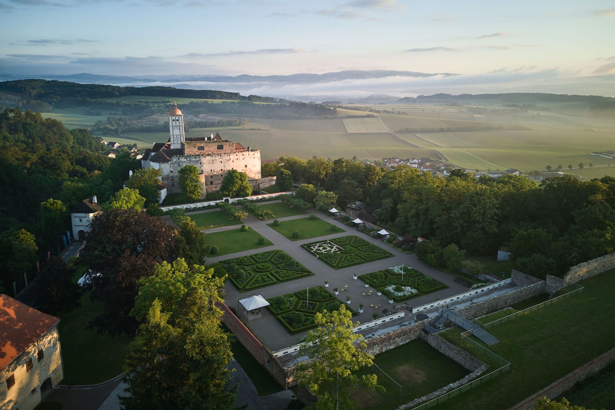 Aerial view of Schallaburg Castle with gardens and surrounding landscape.