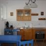 Kitchen in a vacation apartment with wooden furniture, blue chairs and modern equipment.