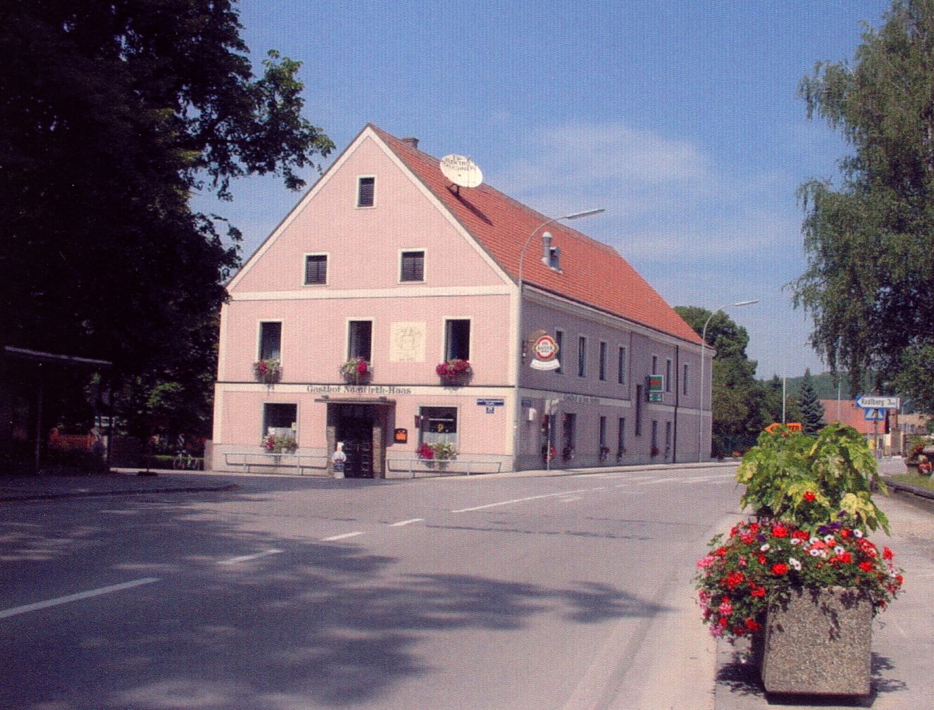 A traditional inn on a street corner decorated with flowers.