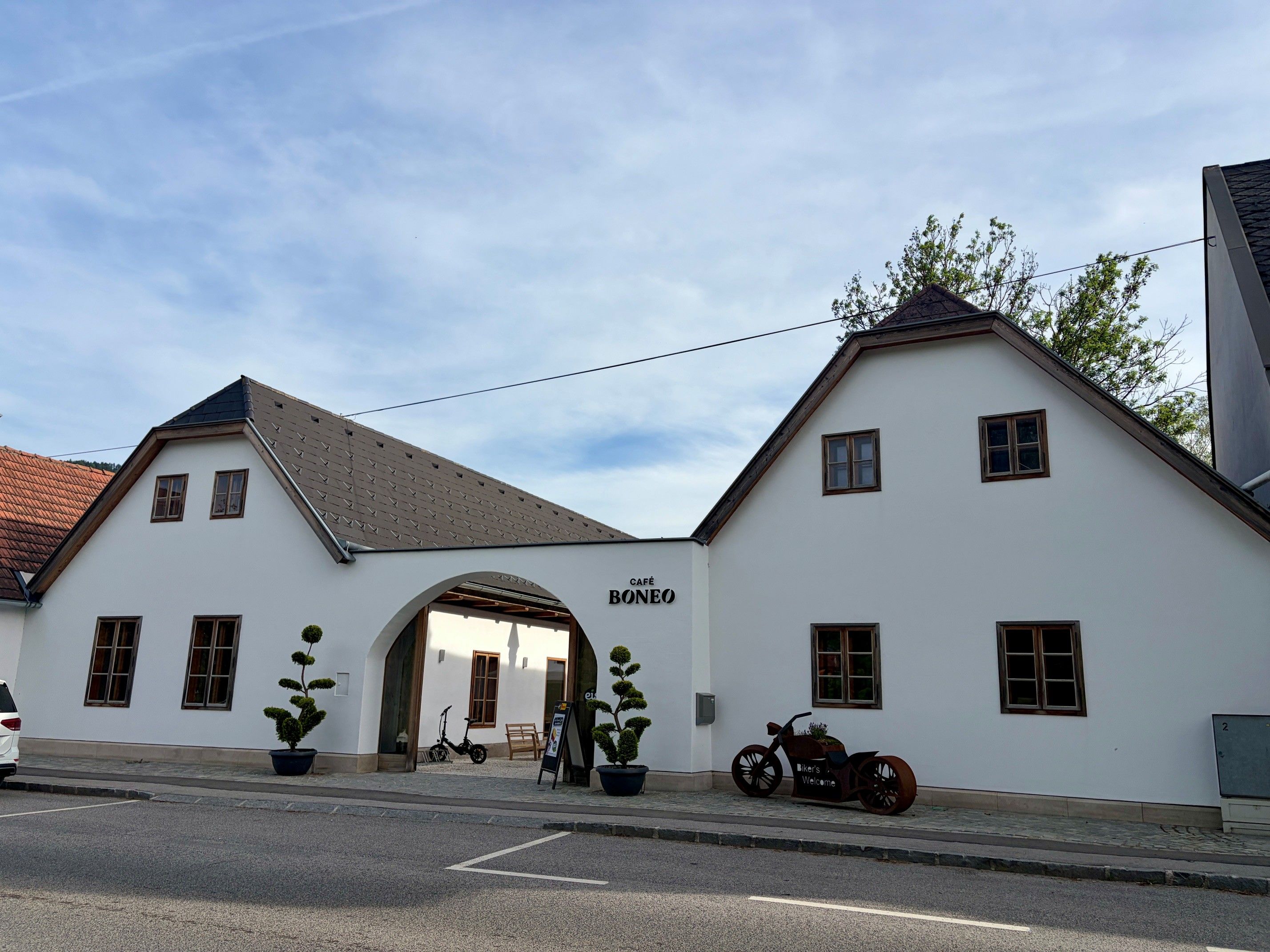Exterior view of the Cafe Boneo with white façade and two gables.