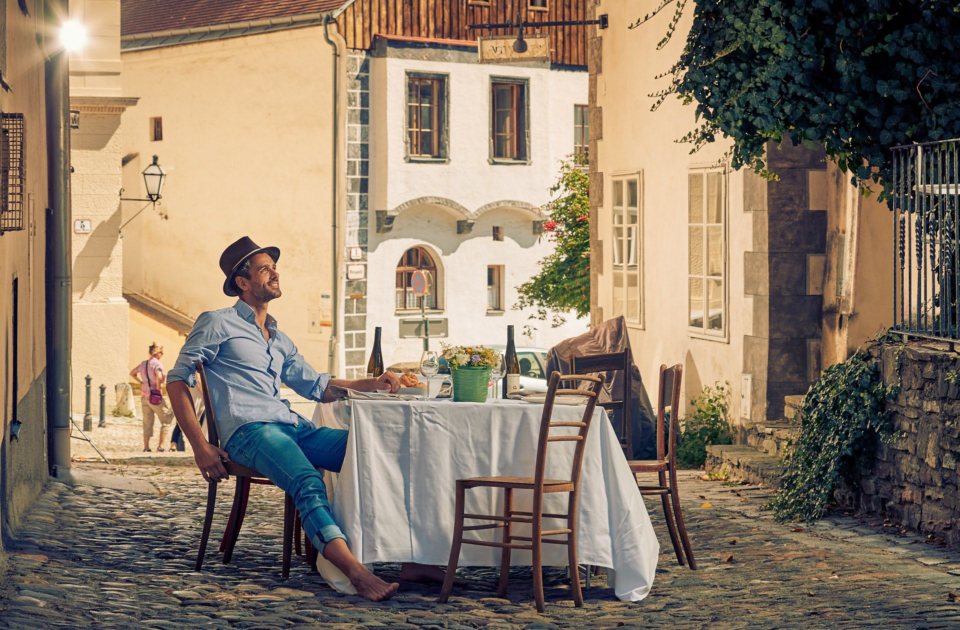 Man sitting at a table in a cobbled alleyway in the old town of Krems.