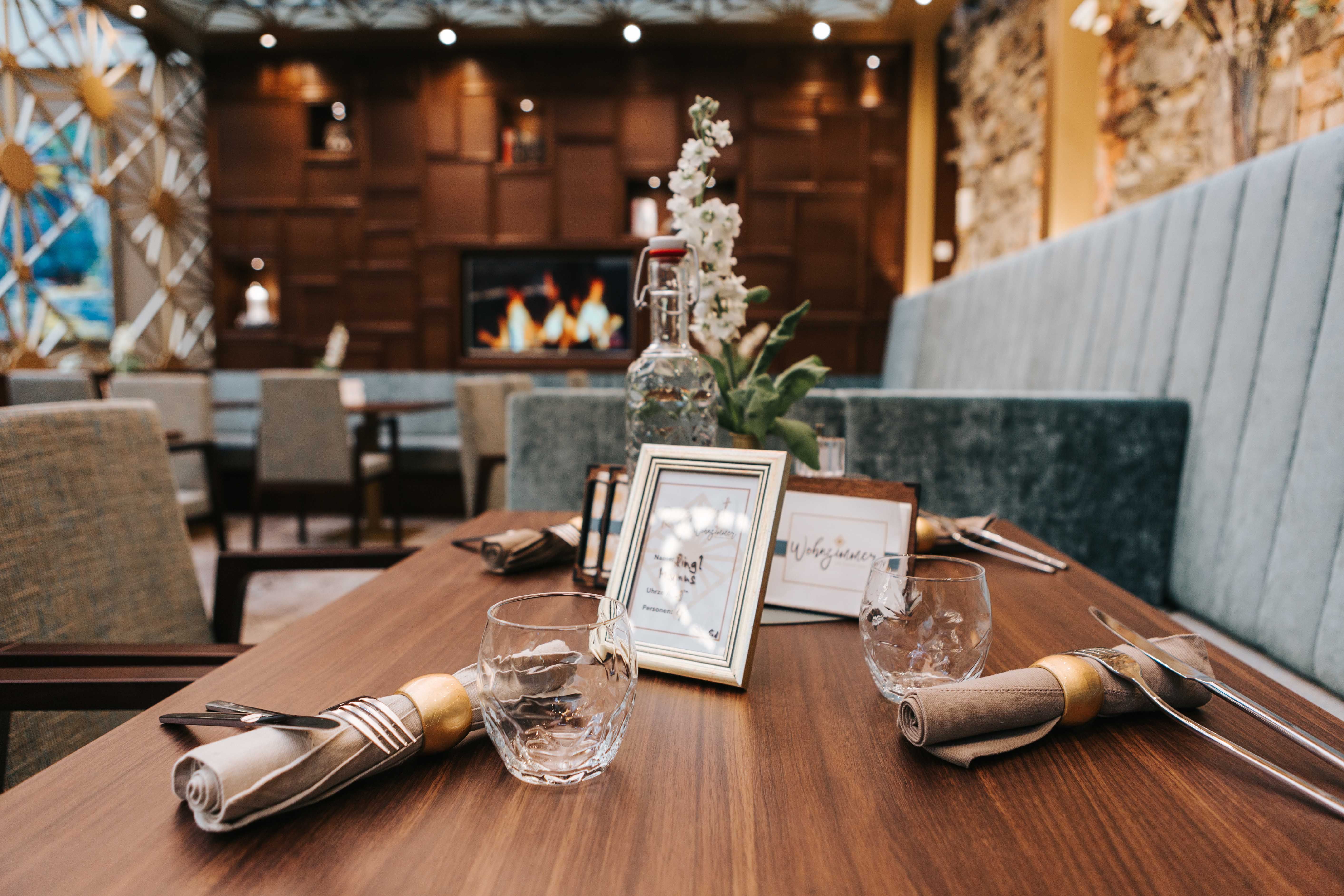 A stylishly laid table in a café with wooden decor and a fireplace in the background.