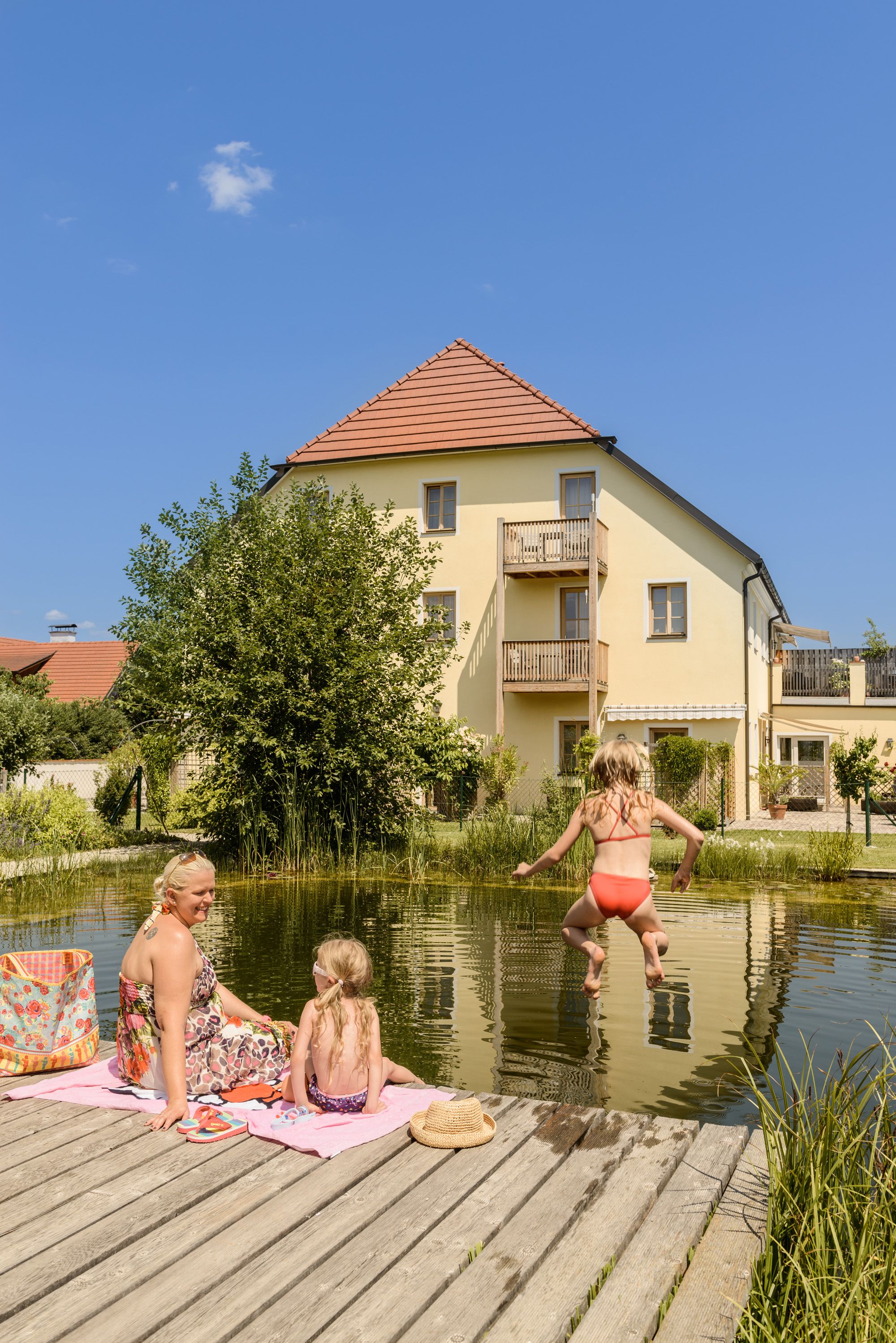A woman and two children at the bathing pond in the ad vineas guest house