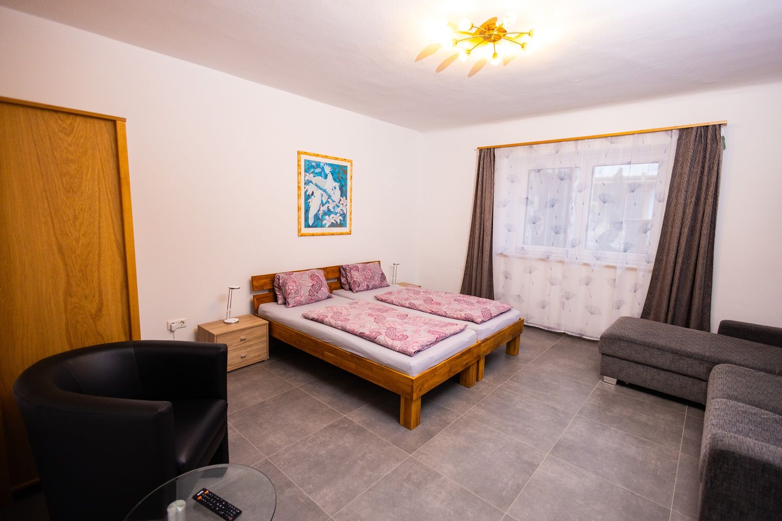 Bedroom with double bed, sofa and armchair.