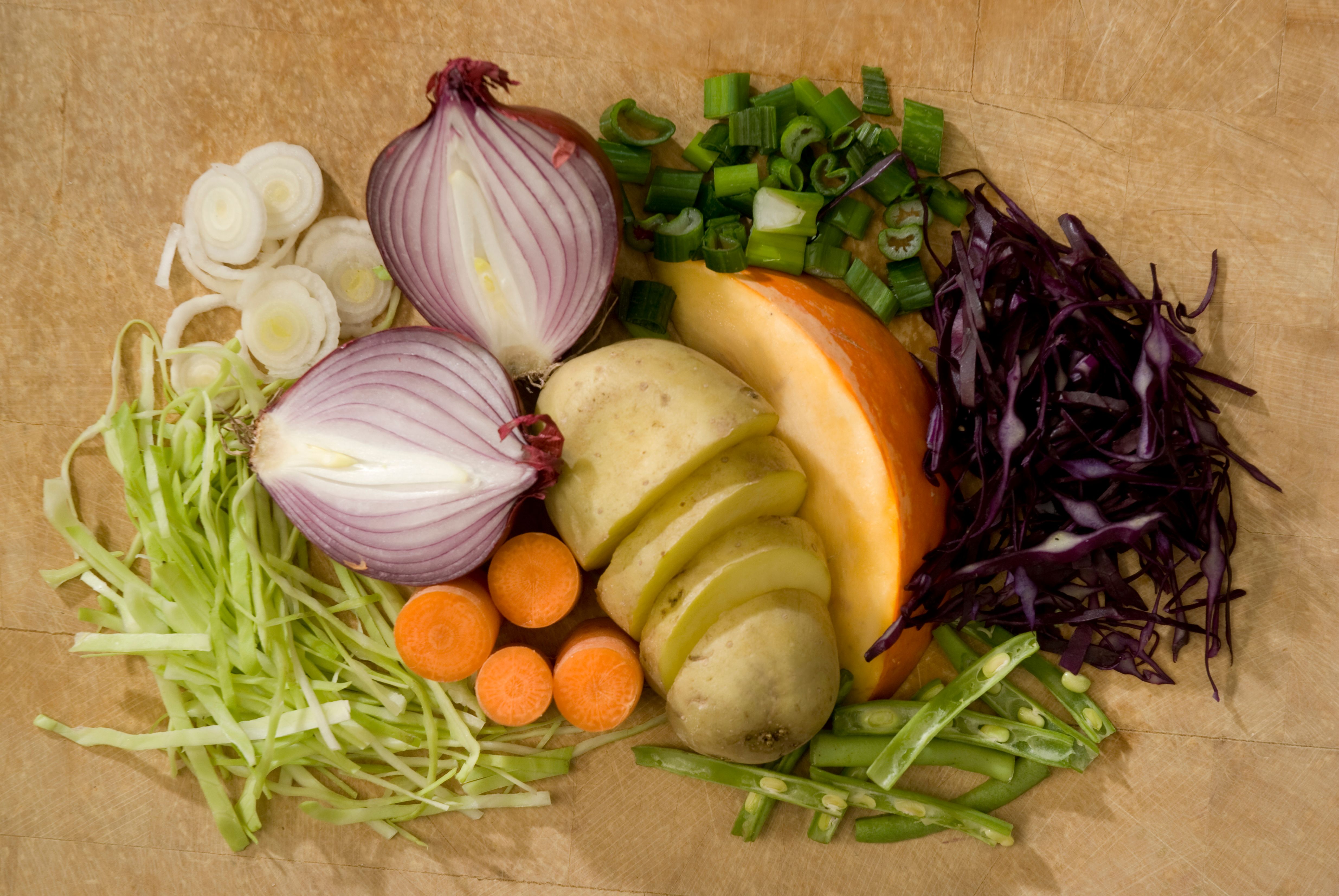 Various vegetables arranged on a wooden board.