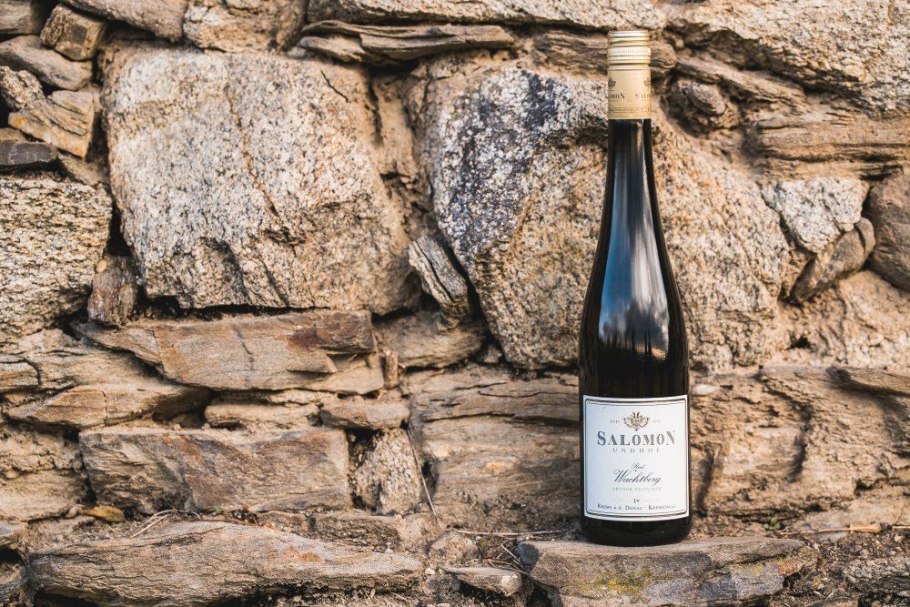 Wine bottle in front of a stone wall.