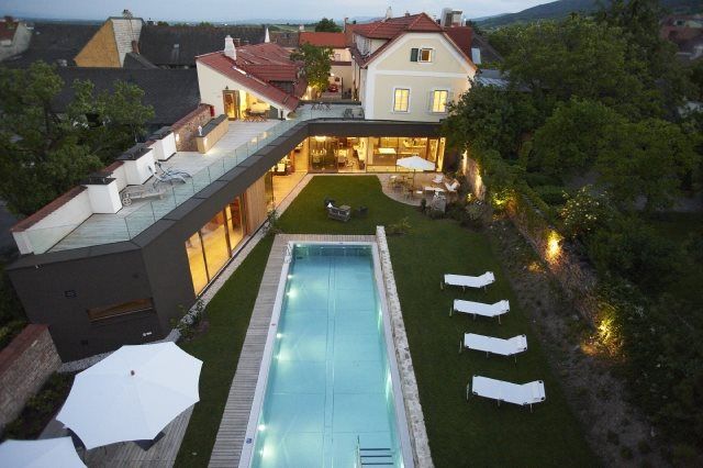 Aerial view of a modern house with pool and garden at dusk.