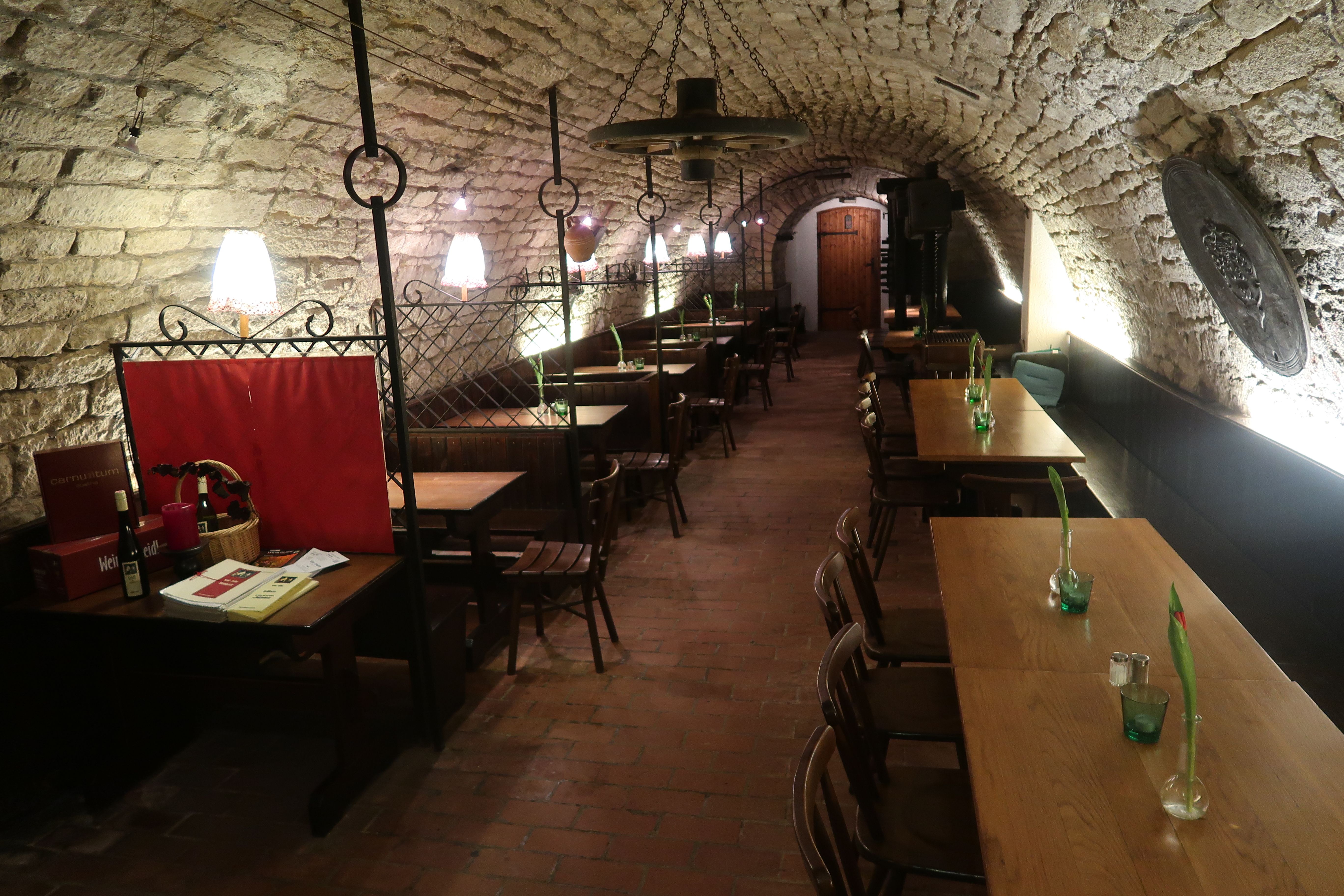 Stone vaulted cellar with tables and armchairs 