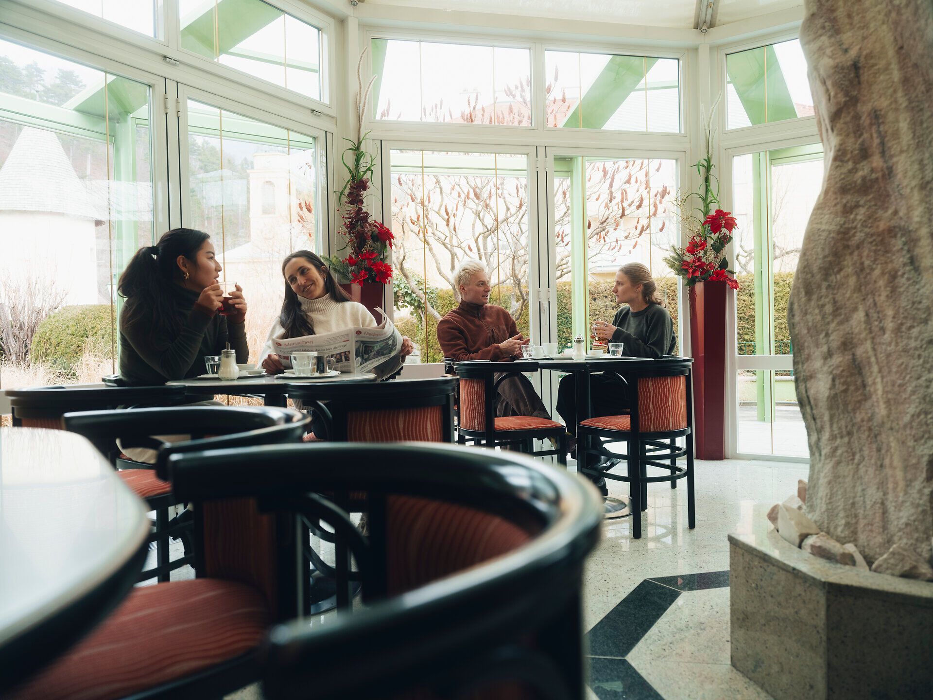 In the cozy atmosphere of Konditorei Nöbauer, guests enjoy delicious treats and stimulating conversation. The large windows offer a magnificent view of the wintry landscape of the Vienna Alps, while the warm colors of the interior create an inviting atmosphere.