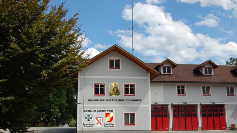 Fire department building with red gates and lettering 'Our free time for your safety'.