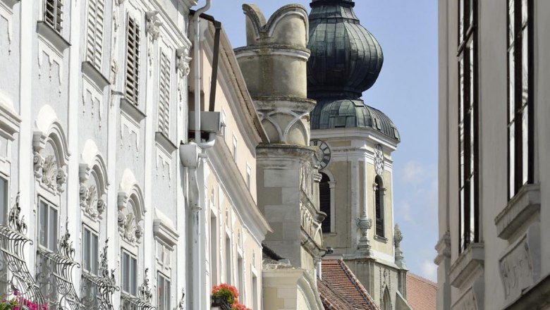 Street scene with historic buildings and church tower in the background.