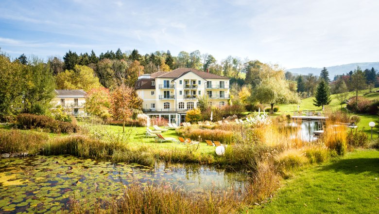 RelaxResort Kothmühle, © Johanna Meinschad A hotel in the middle of a green landscape with a pond and sun loungers.