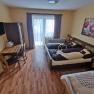 Comfortable bedroom with double bed, table, chairs and balcony access.