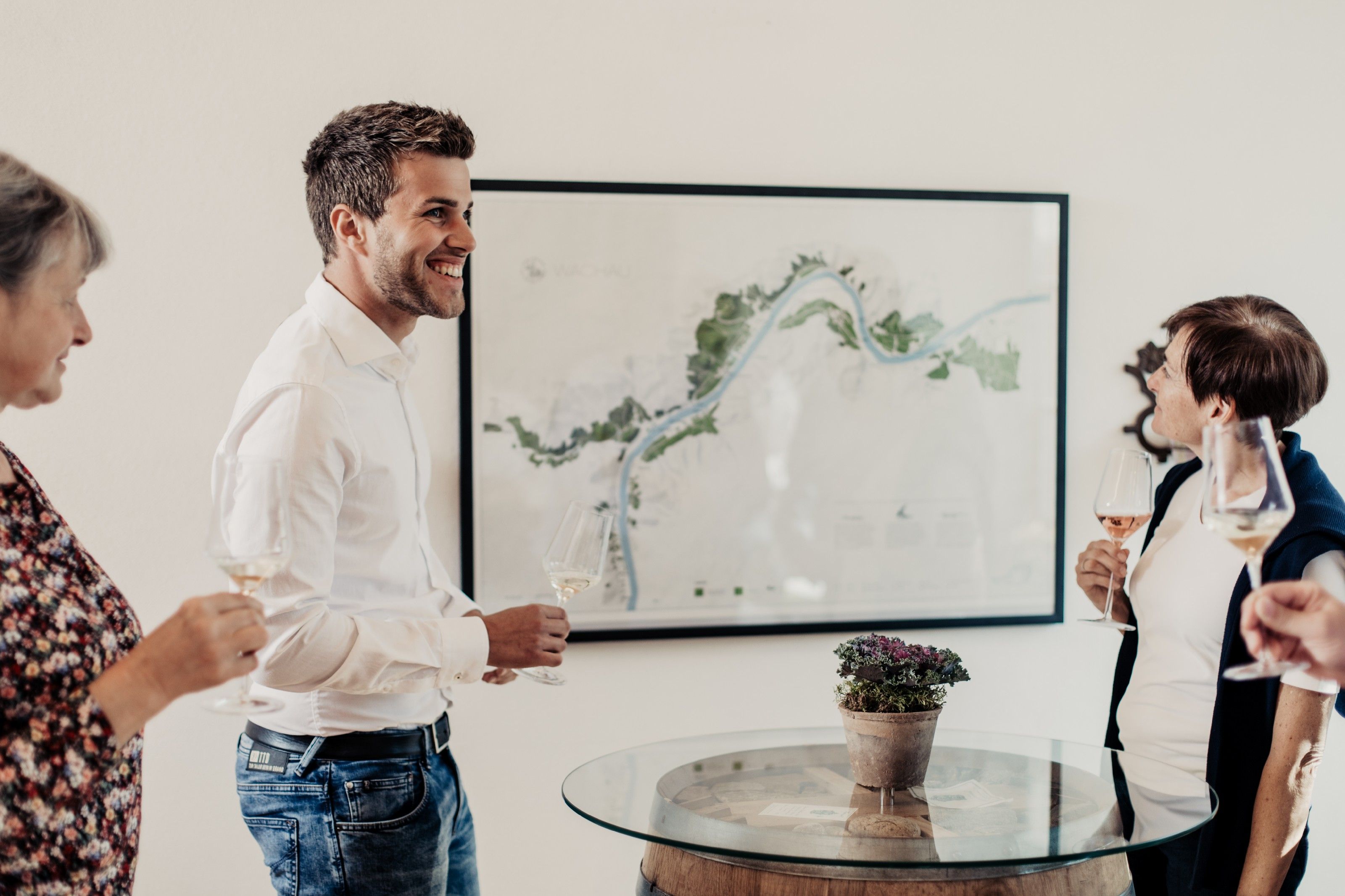 Group of people at a wine tasting in front of a map.