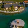Aerial view of chalets on the garden lake with jetty and deckchair.