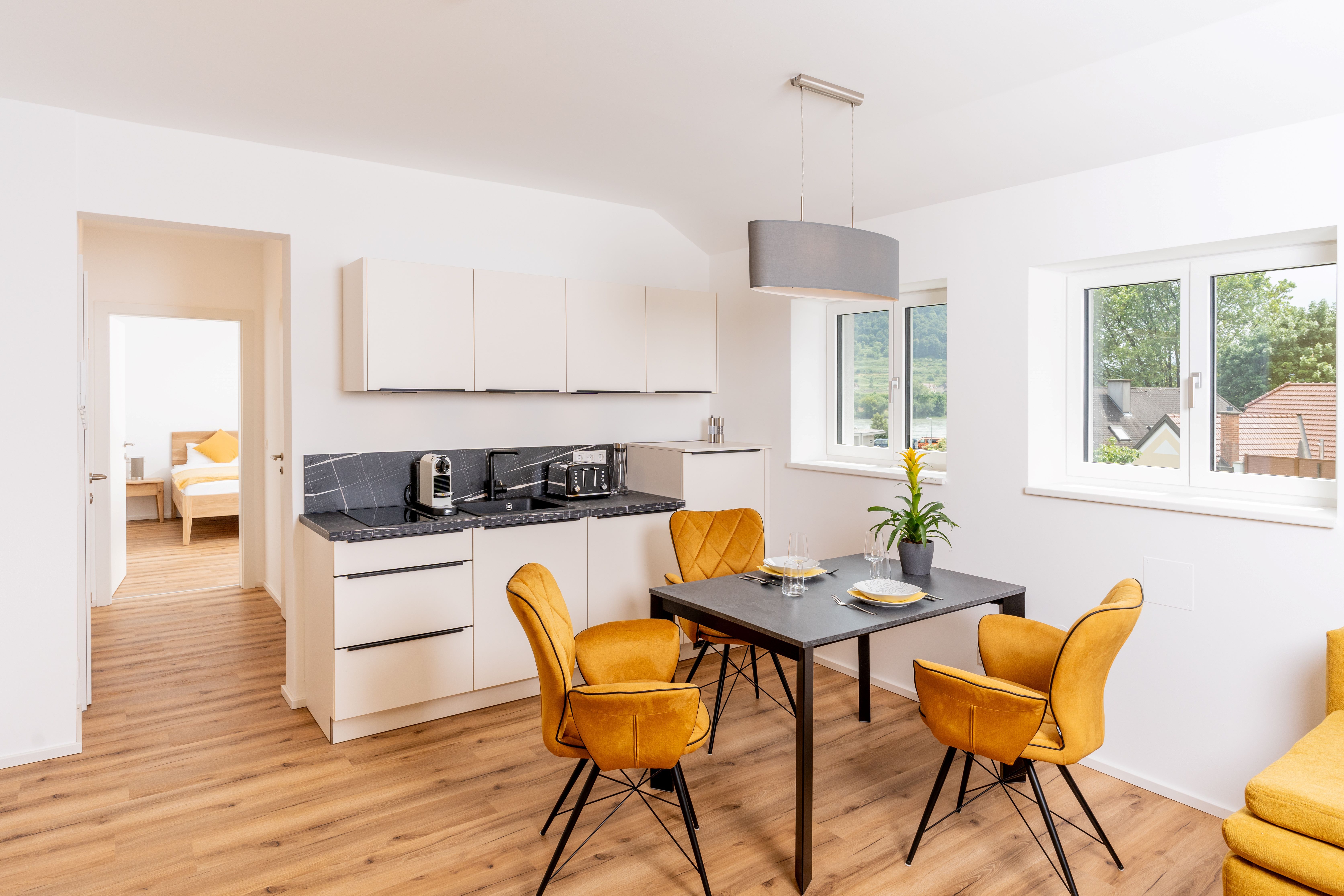Modern kitchen with dining table and yellow chairs in a vacation apartment.