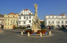 Historic square in Langenlois with baroque column and surrounding buildings.