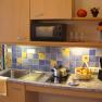 Kitchenette with sink, stove, microwave and decorations.
