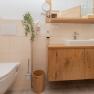 Modern bathroom with wooden washbasin, sink, toilet and towels.