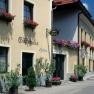 Facade of the Heller guest house with flowers and a white van parked in front of it.