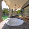 Terrace with whirlpool and sun loungers, view of a pond.