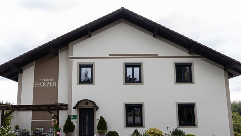 Exterior view of Pension Parzer with garden and terrace.