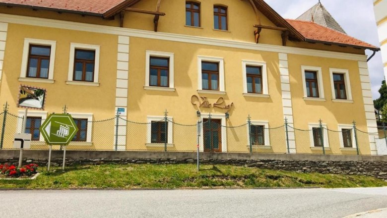 Villa Luef, © Ildiko Davidne Nagy Yellow building with the inscription 'Villa Luef', surrounded by a fence and a road in the foreground.