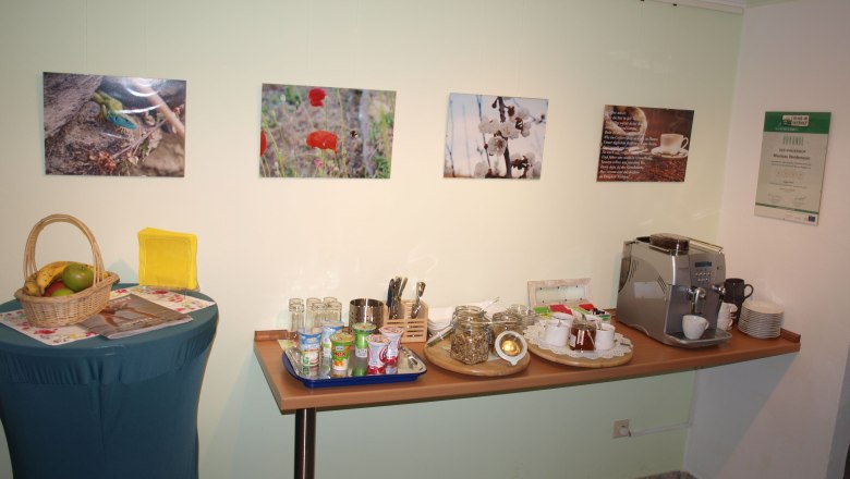 Breakfast buffet with fruit basket, yogurt, muesli and coffee machine.