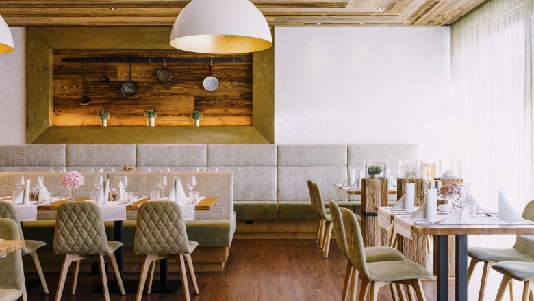 Modern restaurant with wooden elements and elegant table decorations.